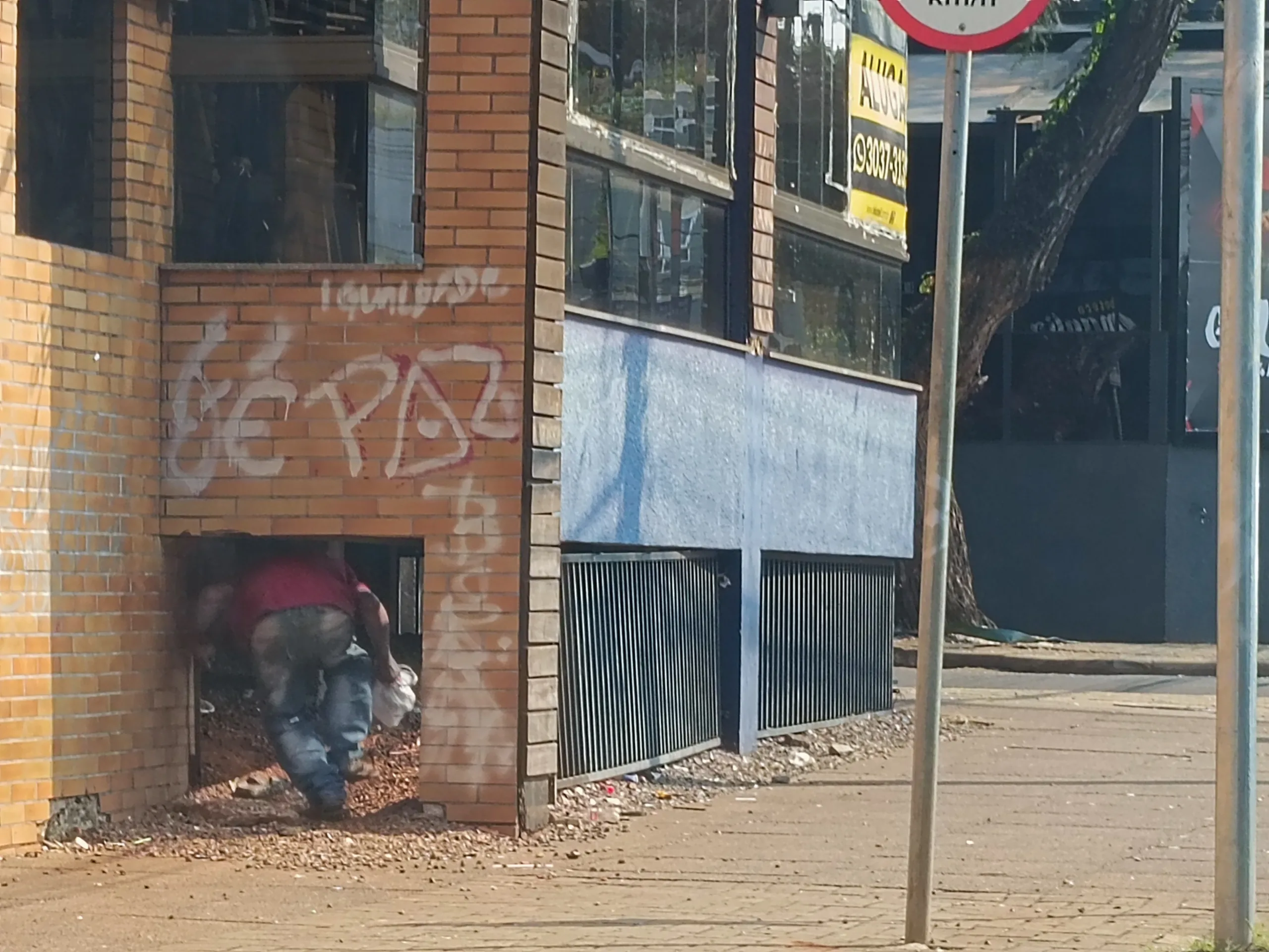 Morador de rua se abriga embaixo de um antigo estabelecimento localizado na esquina das ruas Paraná com Pio XII