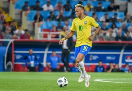 Jogador Neymar jogando bola com a camisa da seleção