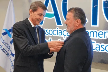 O presidente do Conselho Superior, Genesio Pegoraro, passa bóton a Blazius, simbolizando a troca de comando da entidade