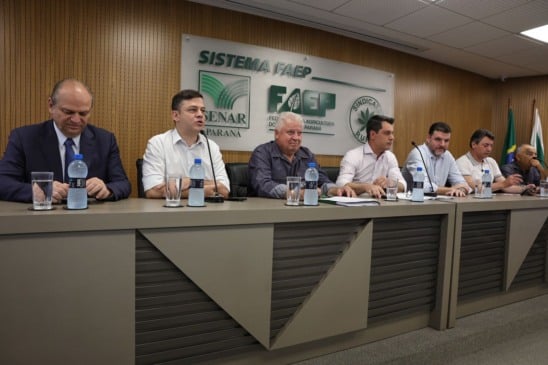 A Assembleia Geral do Sistema FAEP, realizada nesta segunda-feira (2), em Curitiba, consolidou-se como um marco para o planejamento do agronegócio paranaense. O evento reuniu lideranças rurais de todas as regiões do Estado e parlamentares influentes para realizar o balanço de 2025 e definir as metas estratégicas para 2026.

No total, mais de 110 participantes representaram dezenas de sindicatos rurais, reforçando a capilaridade da Federação. Estiveram presentes os deputados federais Pedro Lupion, Ricardo Barros, Tião Medeiros e Sérgio Souza, além da deputada estadual Maria Victoria.

Articulação Política e Conquistas do Agro em 2025
O presidente do Sistema FAEP, Ágide Eduardo Meneguette, enfatizou a importância da união entre o setor produtivo e o Legislativo. Durante a abertura, Meneguette relembrou vitórias cruciais, como a derrubada do projeto de aumento das custas cartoriais no Paraná, que previa reajustes de até 532%.

Outros avanços destacados foram:

Piscicultura: Barragem da taxação da importação de tilápia e manutenção da espécie fora da lista de "invasoras".

Setor Leiteiro: Implementação da lei estadual que proíbe a reconstituição de leite em pó importado.

Desafios e Prioridades para 2026
Apesar das conquistas, o cenário para 2026 exige atenção. O seguro rural é a principal preocupação, devido ao veto presidencial ao dispositivo que impedia o contingenciamento de recursos. No Paraná, o impacto é direto: em 2025, foram contratadas 19,5 mil apólices, protegendo 944 mil hectares (R$ 4 bilhões em valor segurado).

A Reforma Tributária, em vigor desde o início do ano, também foi tema central. O Sistema FAEP disponibilizou uma cartilha gratuita para orientar produtores sobre a transição progressiva das obrigações fiscais.

Fortalecimento do Sistema Sindical e Inovação
Para modernizar a gestão no campo, Meneguette realizou a entrega de kits digitais (notebooks e celulares) a cada sindicato rural. No campo da capacitação, os números do SENAR-PR impressionam:

ATeG (Assistência Técnica e Gerencial): 14.713 visitas em mais de 6 mil propriedades.

Formação Profissional: 11.273 cursos realizados, capacitando 237 mil pessoas.

Além disso, o Sistema FAEP confirmou o avanço do Centro de Excelência do Leite, com previsão de entrega para 2027, e uma missão técnica aos Estados Unidos focada em Inteligência Artificial e automação agrícola.