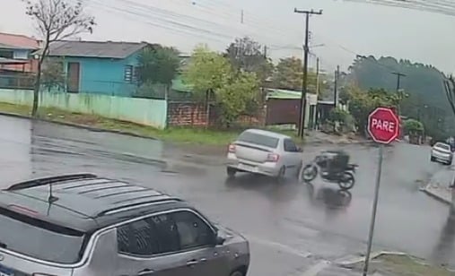 Motociclista sofre grave acidente entre moto e carro no Bairro Periolo, em Cascavel, e é encaminhado ao Hospital Universitário - Foto: Câmera de Monitoramento/SOT Motociclista sofre grave acidente entre moto e carro no Bairro Periolo, em Cascavel, e é encaminhado ao Hospital Universitário - Foto: Câmera de Monitoramento/SOT